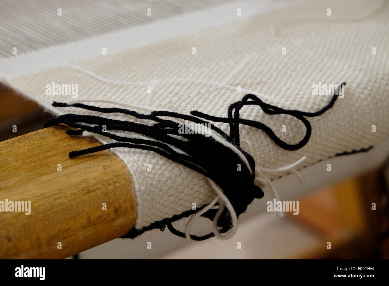 Traditional Jewish Tzitzis fringes strings of one corner of a Talit prayer shawl laying in a loom Stock Photo