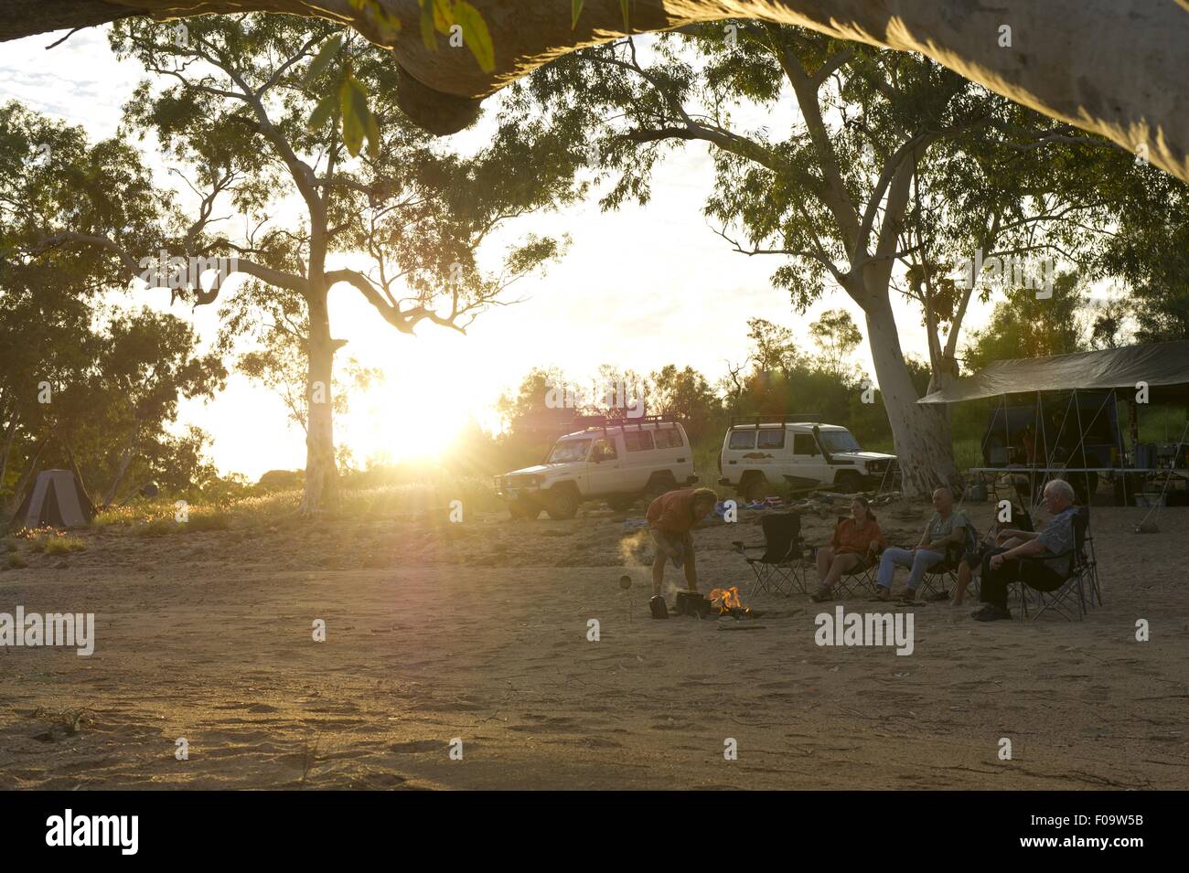 People sitting around camp fire in Ormiston Creek, Alice Springs, Australia Stock Photo