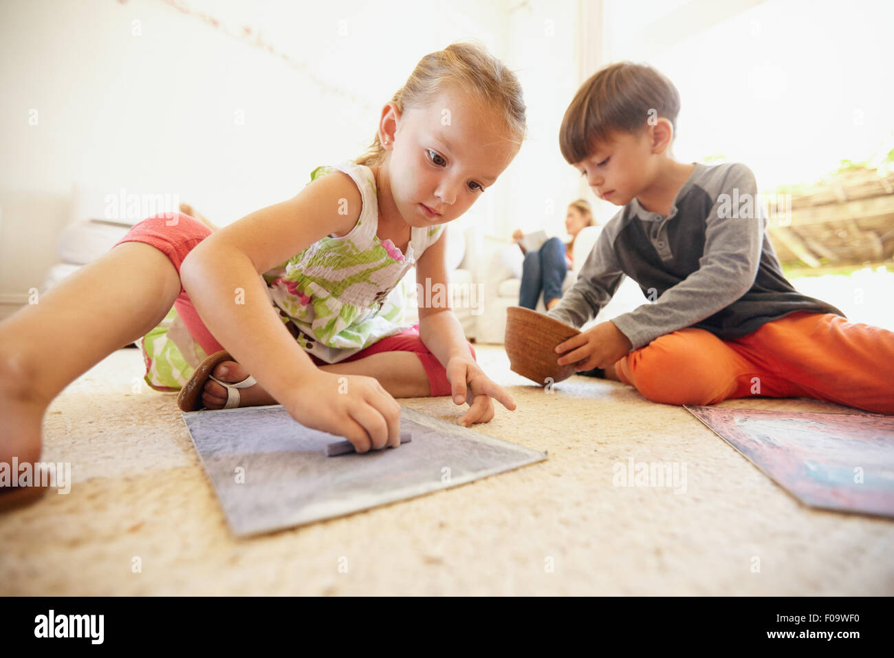 Little boy and girl coloring pictures with chalk colors 