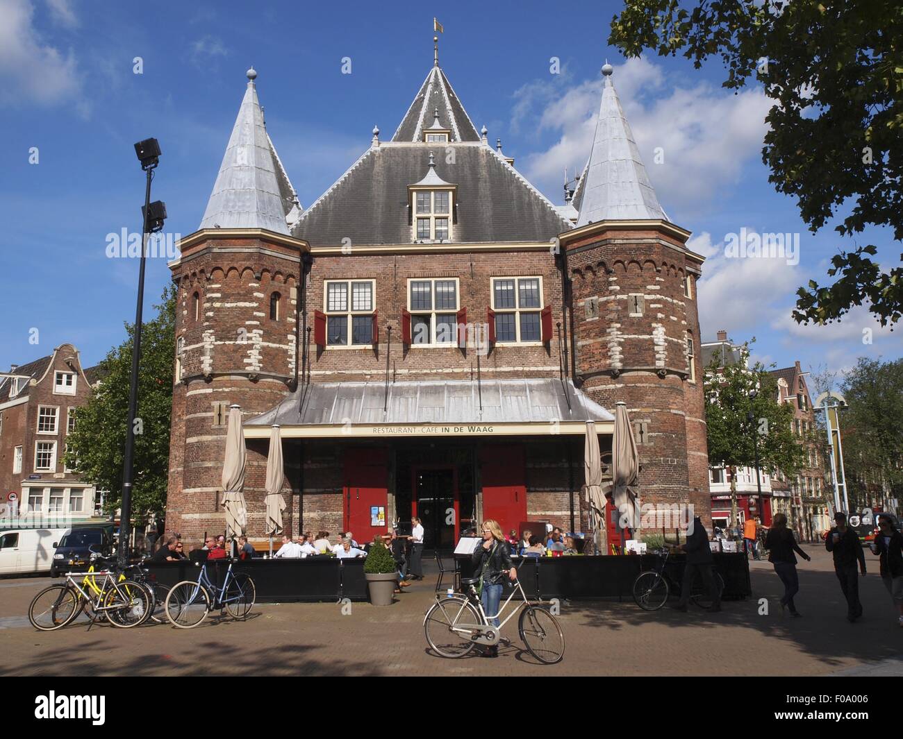 Tourists standing and cycling outside Waag monument in Nieuwmarkt, Amsterdam, Netherlands Stock Photo