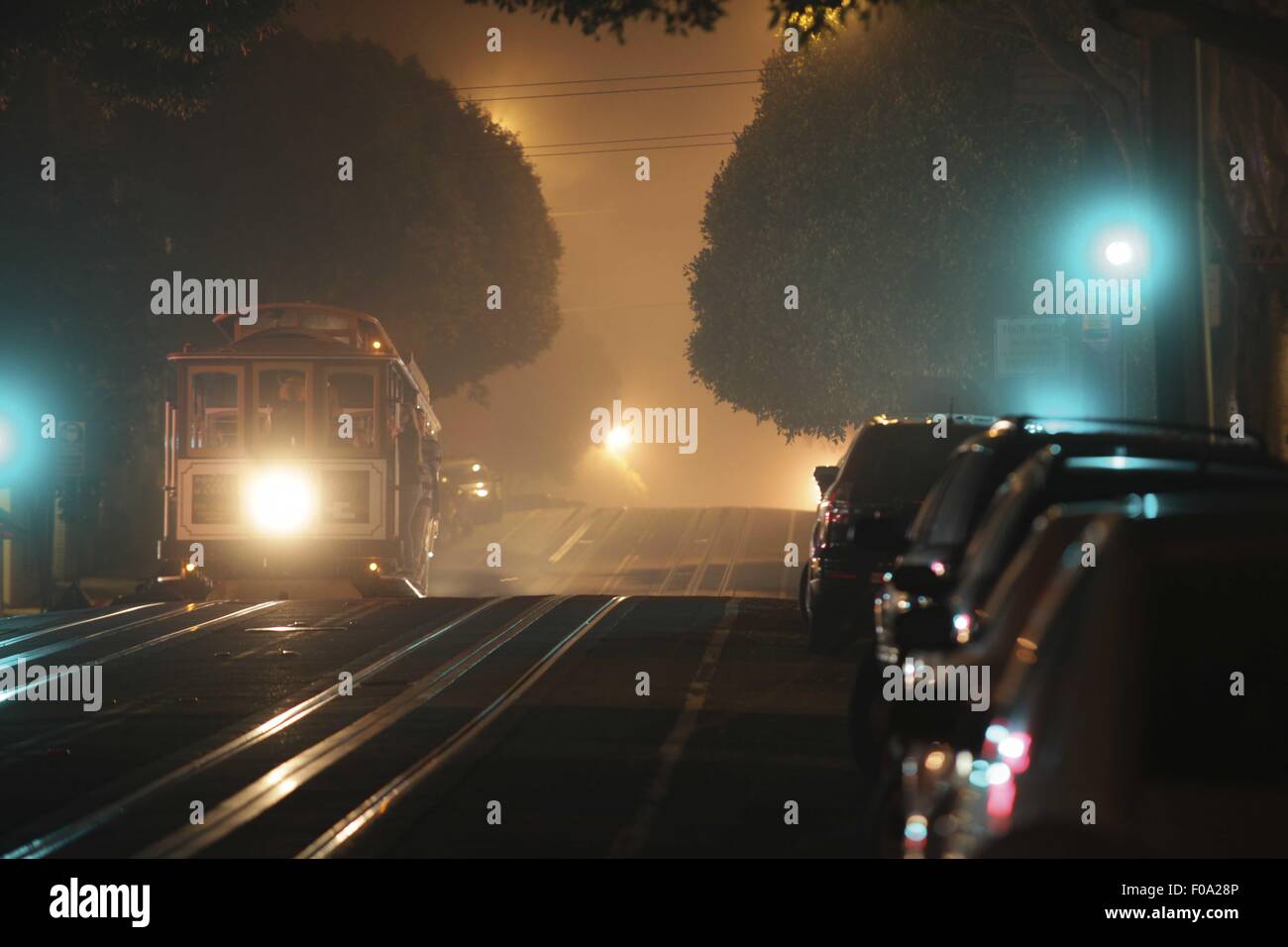 Cable car on illuminated road at night in San Francisco, California ...