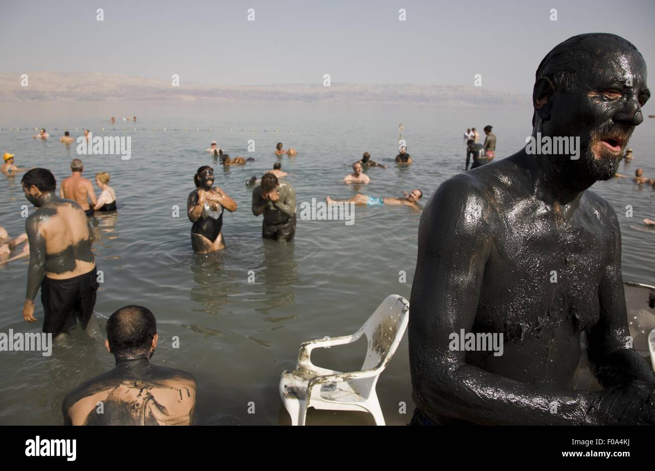 People with mud on body at Ein Gedi Beach, Dead Sea, Israel Stock Photo