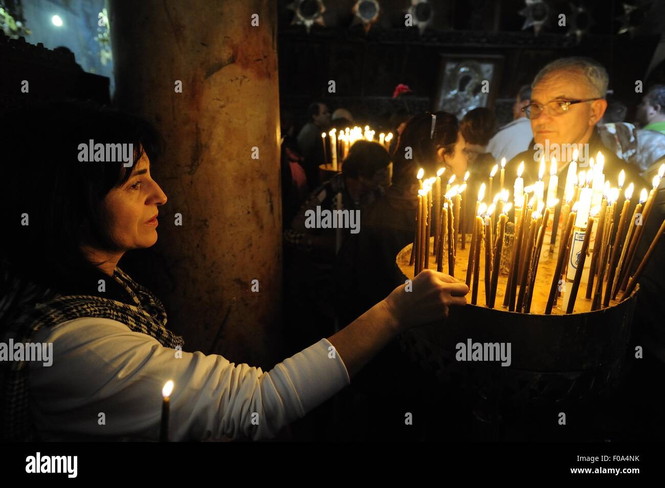People lighting candle at christmas fair in Church of the Nativity