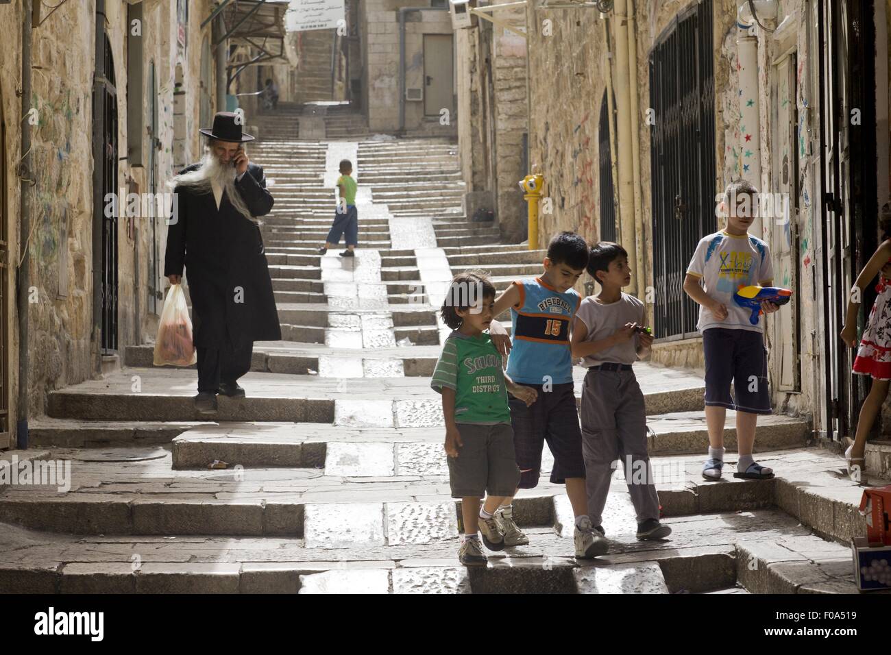 Man and children on steps in alley at Old City, Jerusalem, Israel Stock Photo
