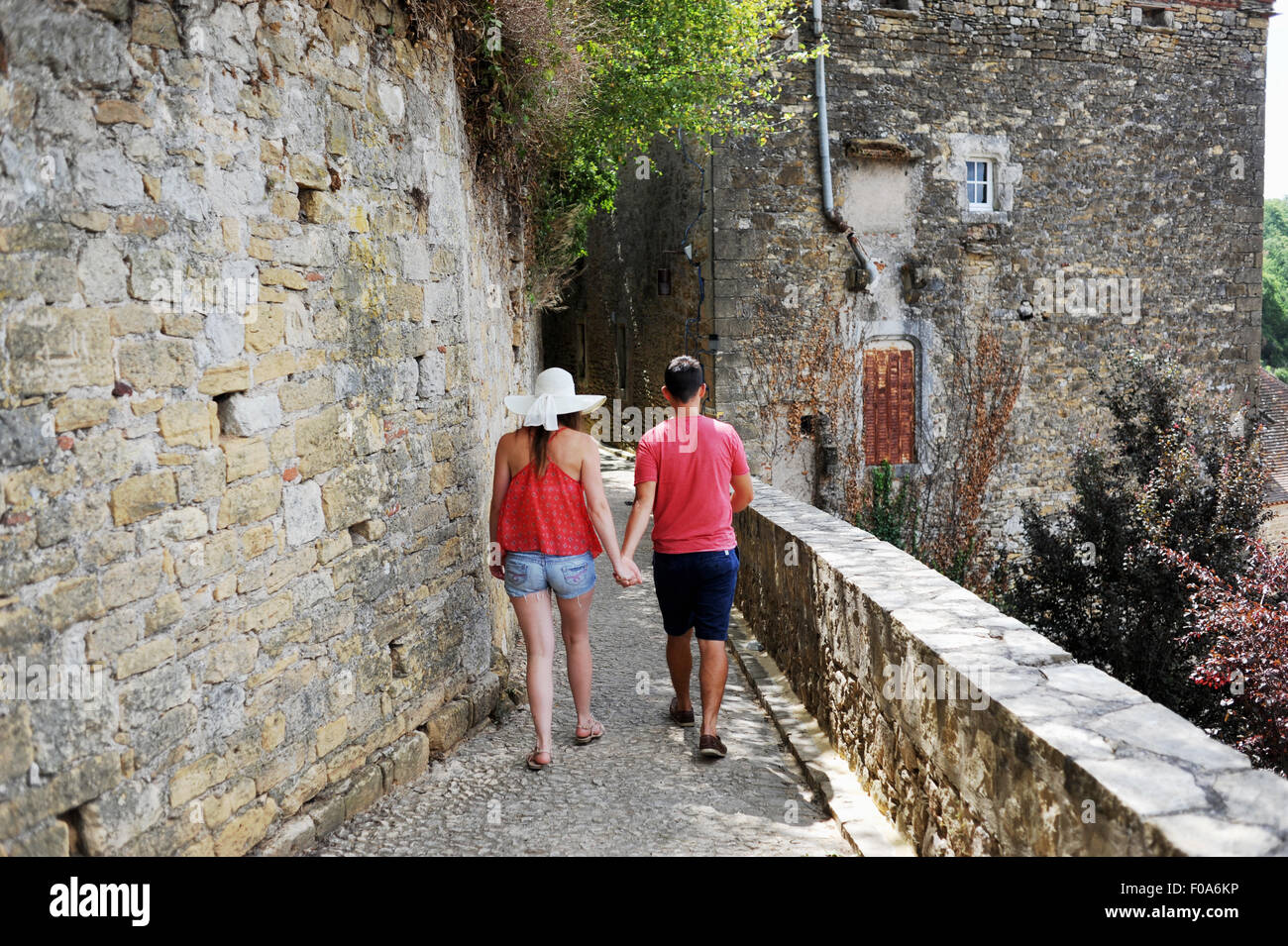 Young couple walking hand in hand on holiday through Puy l'Eveque in Midi Pyrenees region of France Stock Photo
