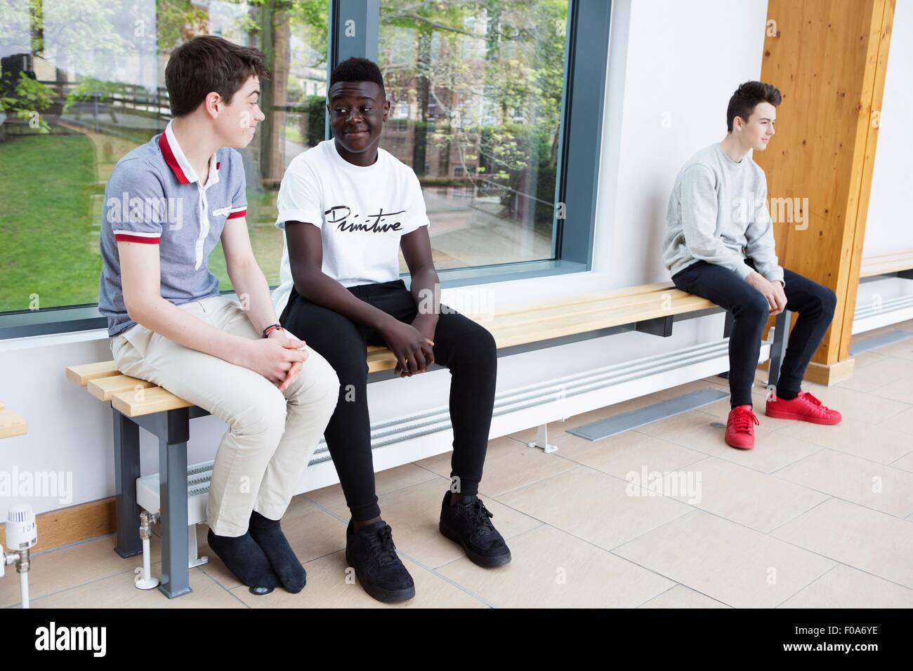 Teenage boys chatting on bench Stock Photo
