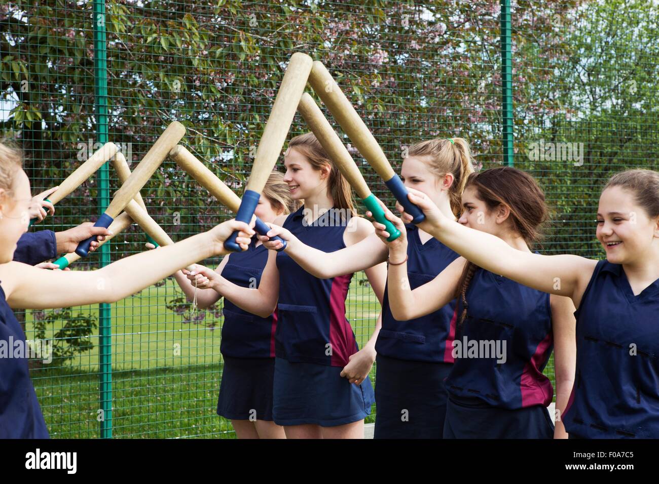 Group of students putting rounders bats together Stock Photo