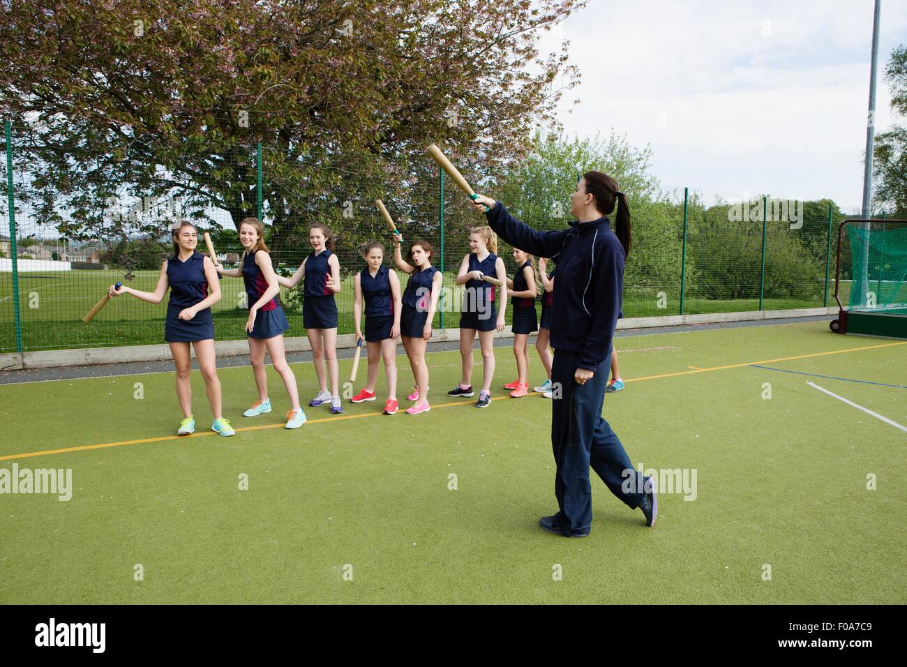 Students and rounders coach on field Stock Photo