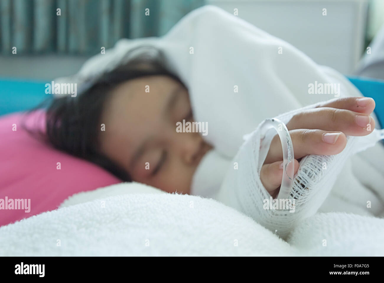 Illness asian kids asleep on a sickbed in hospital, saline intravenous (IV) on hand Stock Photo