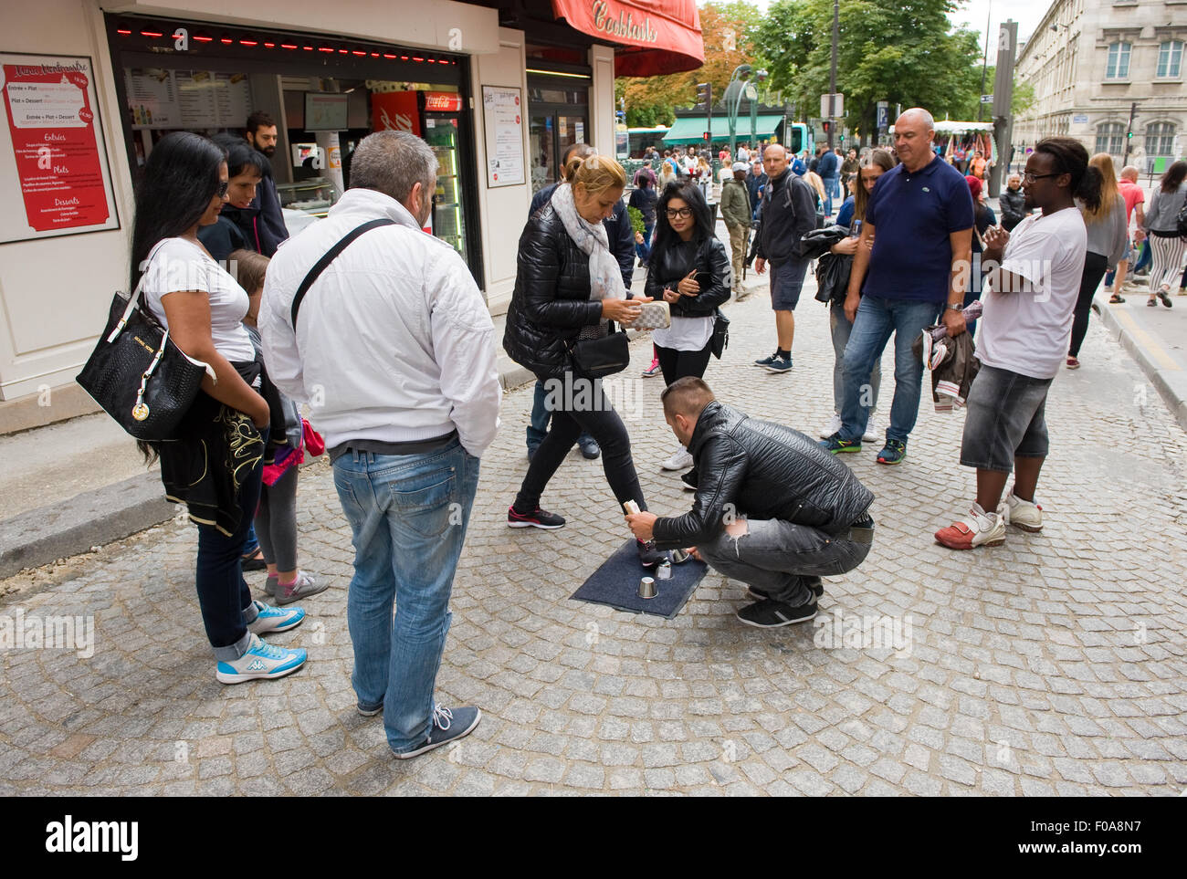 PARIS, FRANCE - JULY 28, 2015: A man is playing a conjuring trick game what is illegal on a street in Paris in france Stock Photo