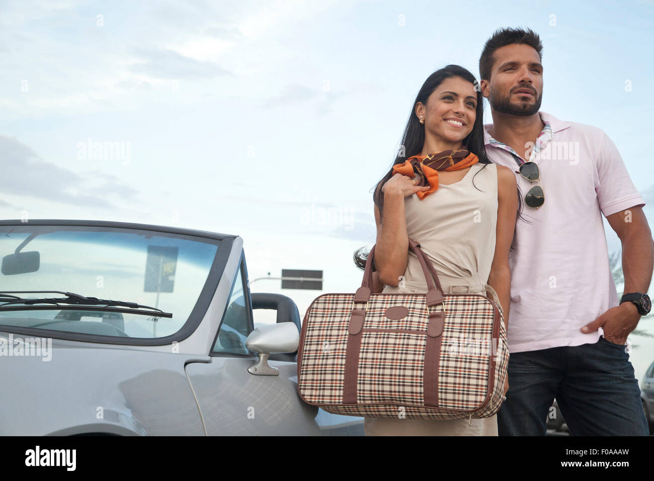 Portrait of mid adult couple standing by convertible car Stock Photo