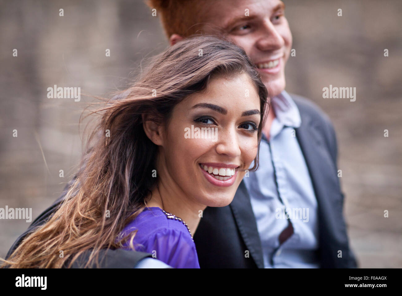Young couple standing together, outdoors, looking away, smiling Stock Photo