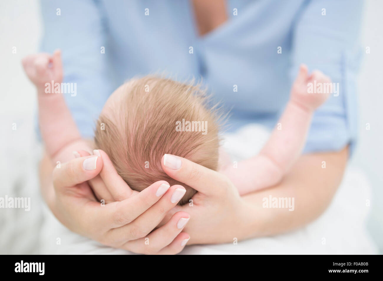 Mother cradling baby in arms Stock Photo Alamy