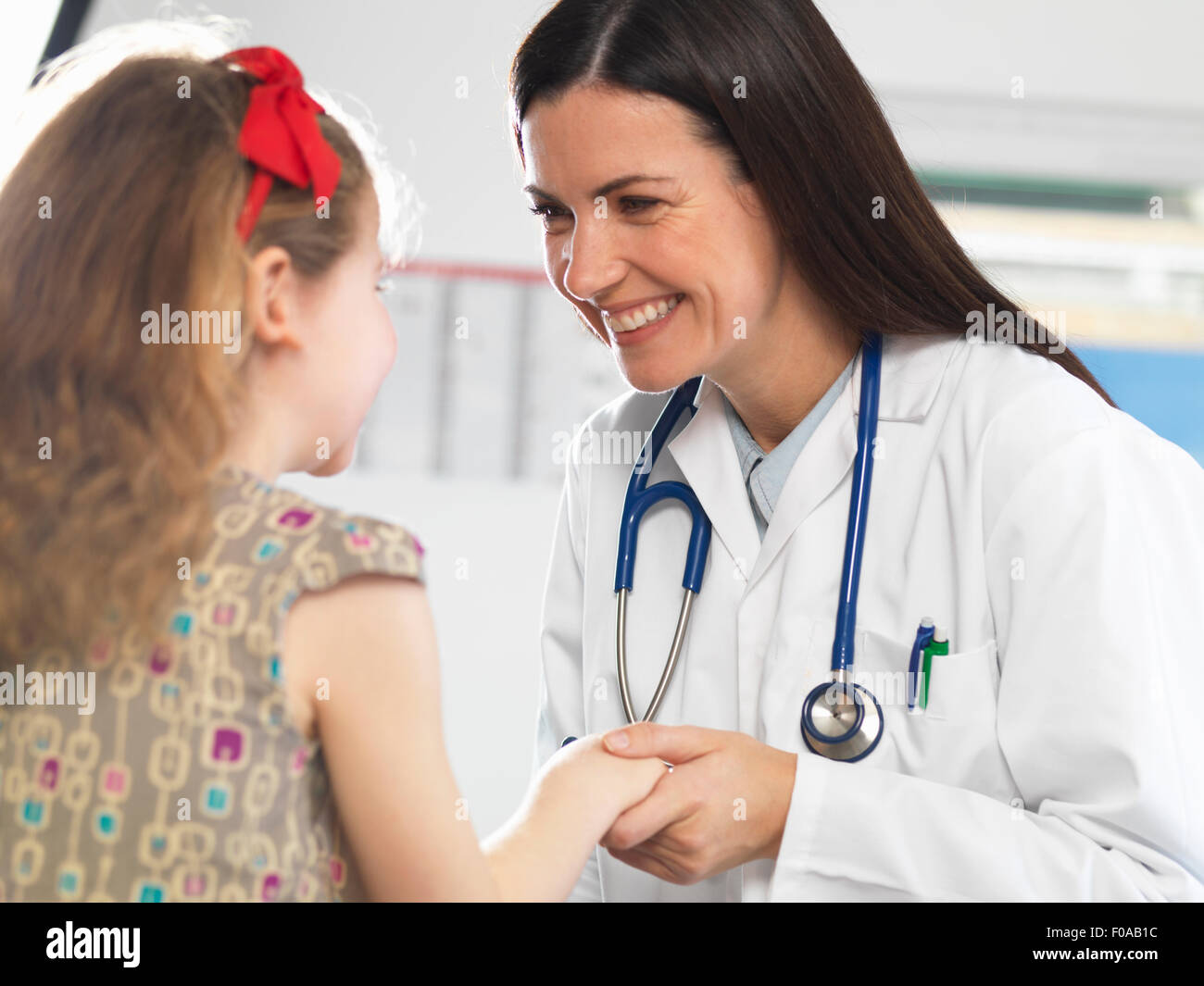 Doctor bonding with young girl during consultation Stock Photo