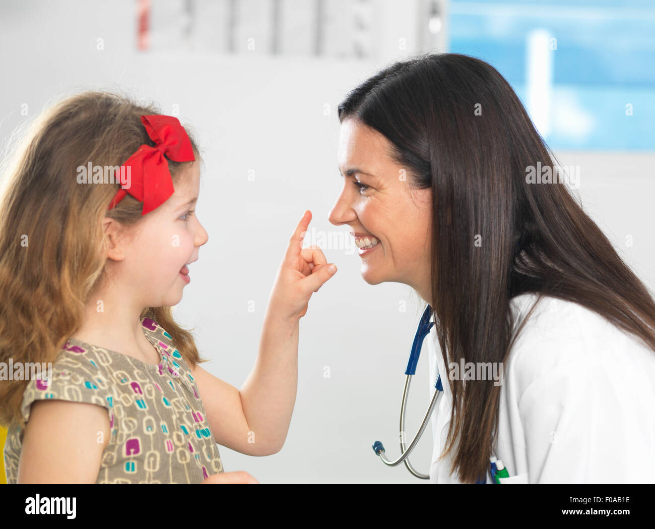 Doctor bonding with young girl during consultation Stock Photo