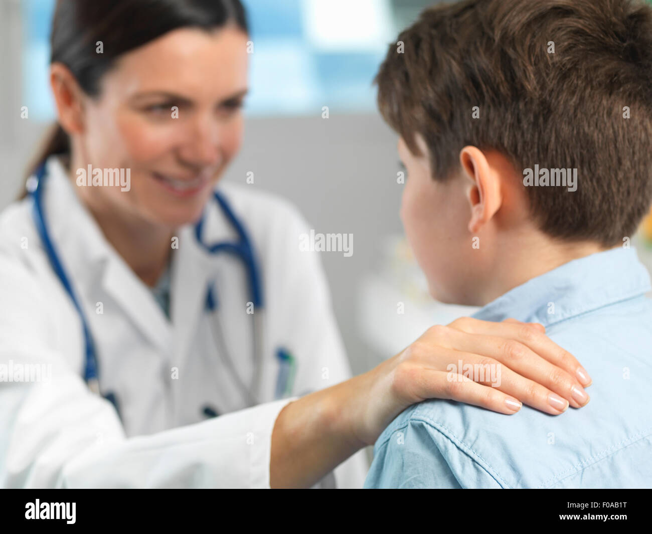 Doctor comforting young boy in clinic Stock Photo