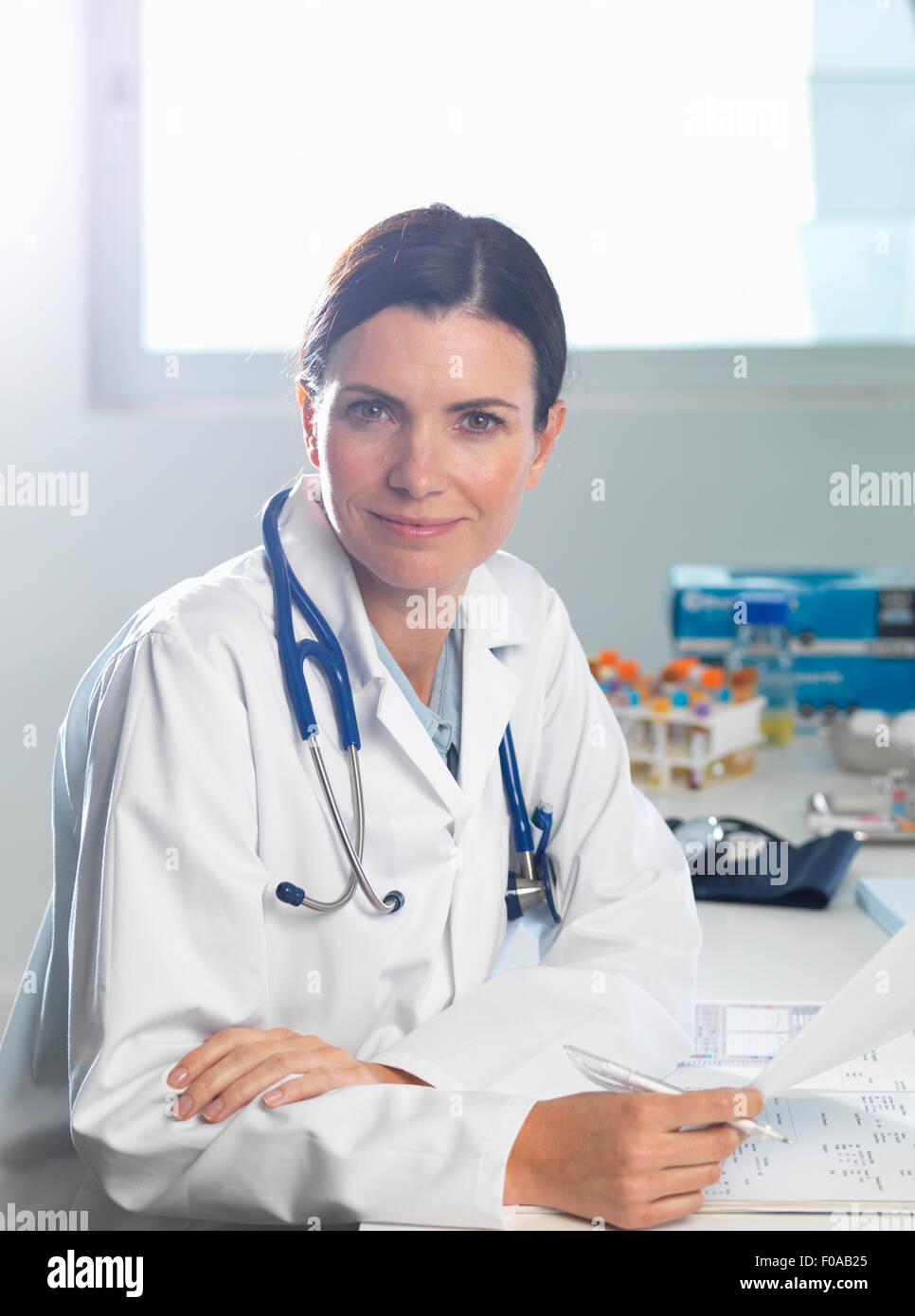 Doctor at desk reviewing patient's notes Stock Photo