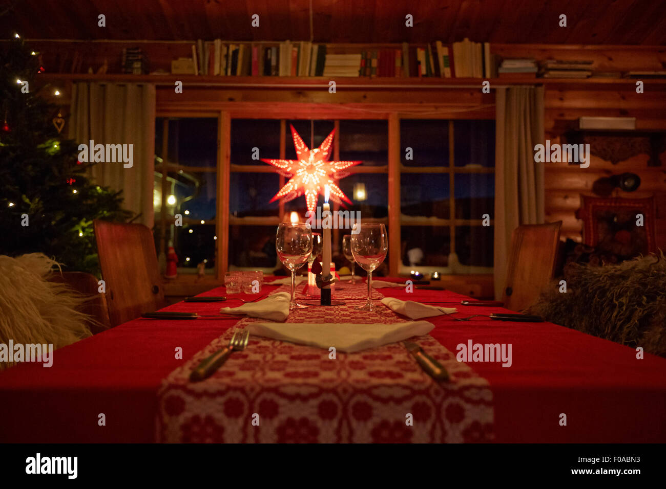 Table set for Christmas in log cabin at night Stock Photo