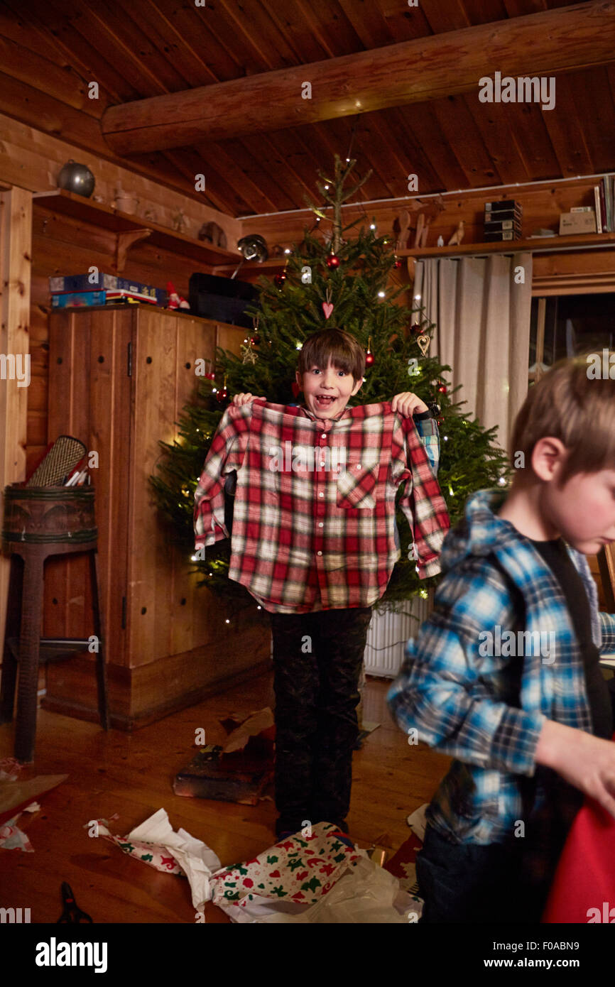 Joyful boy holding up Christmas shirt Stock Photo