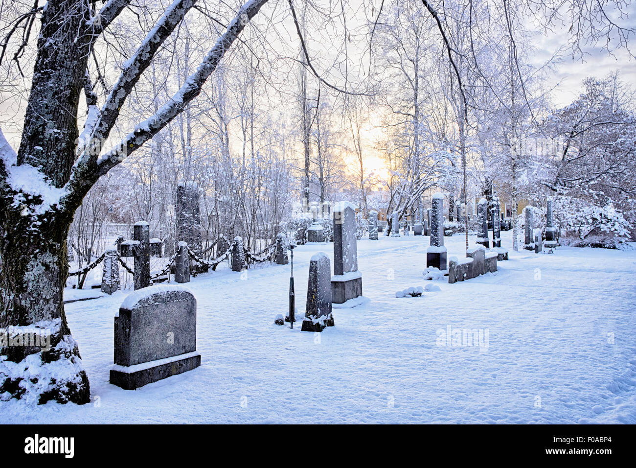 View of grave stones in snow covered cemetery at dusk, Hemavan, Sweden Stock Photo