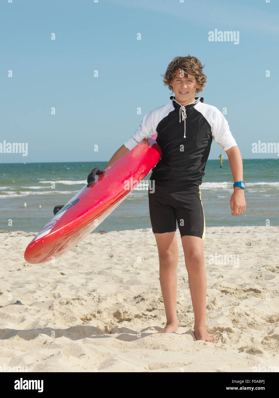 Portrait of teenage boy nipper (child surf life savers) carrying