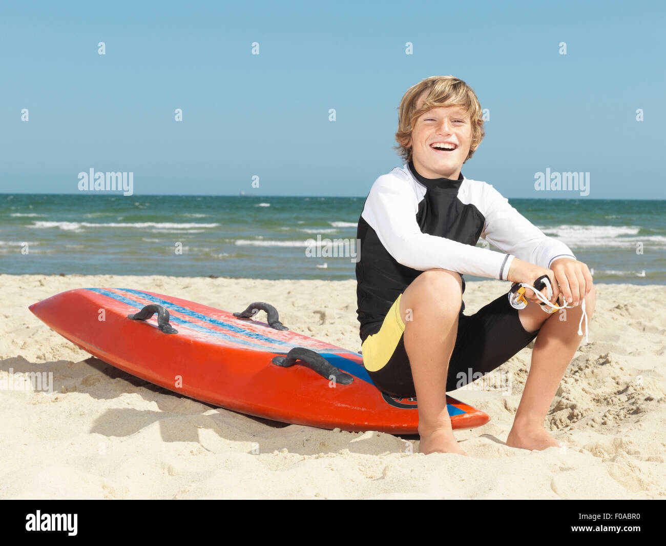 Portrait of confident boy nipper (child surf life savers) sitting on