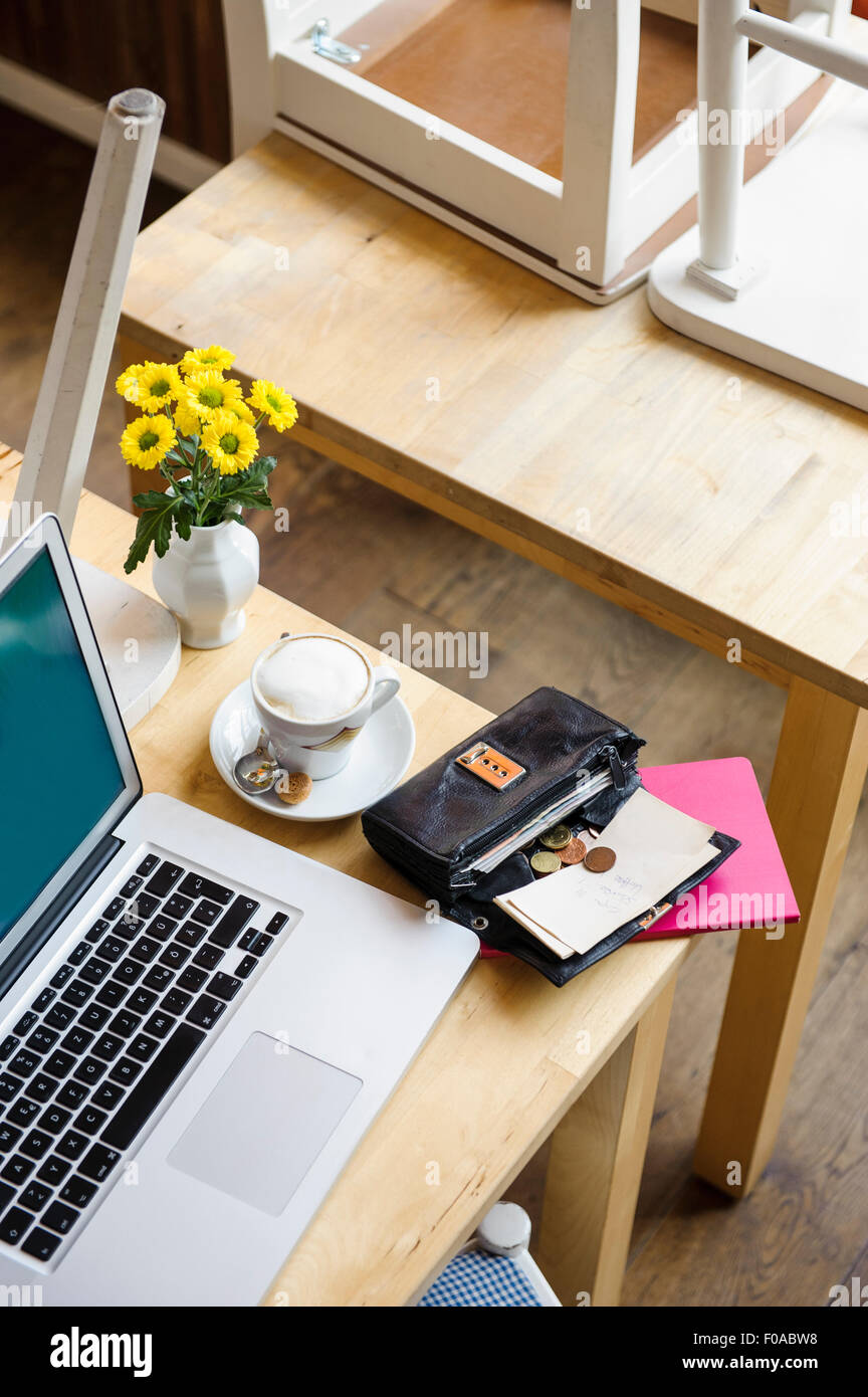 Laptop and open purse on table, high angle view Stock Photo