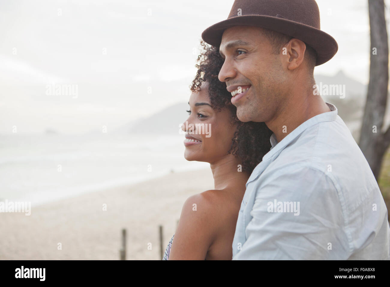 Smiling couple looking out over beach, Rio De Janeiro, Brazil Stock Photo