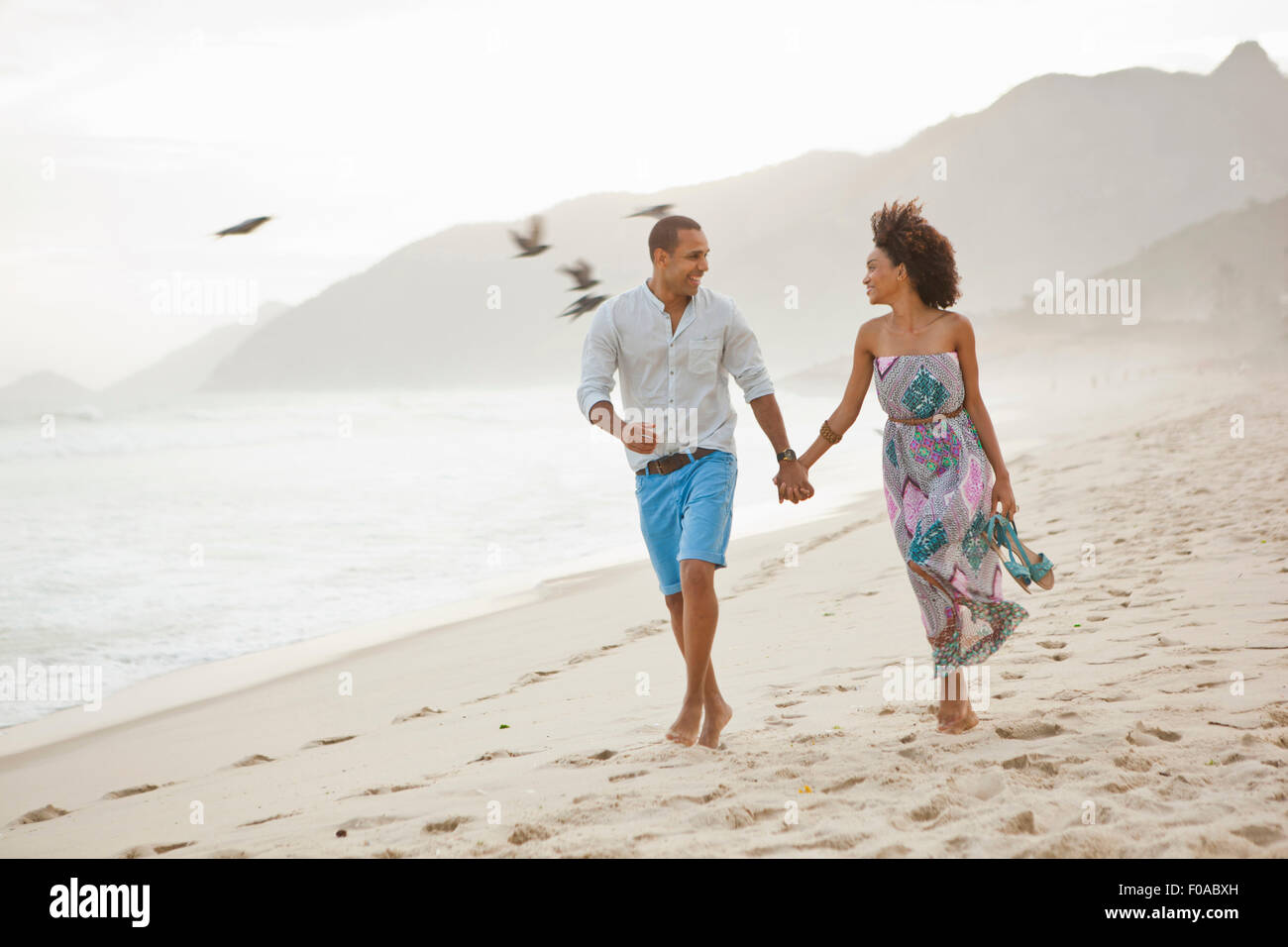 Couple strolling on beach, Rio De Janeiro, Brazil Stock Photo