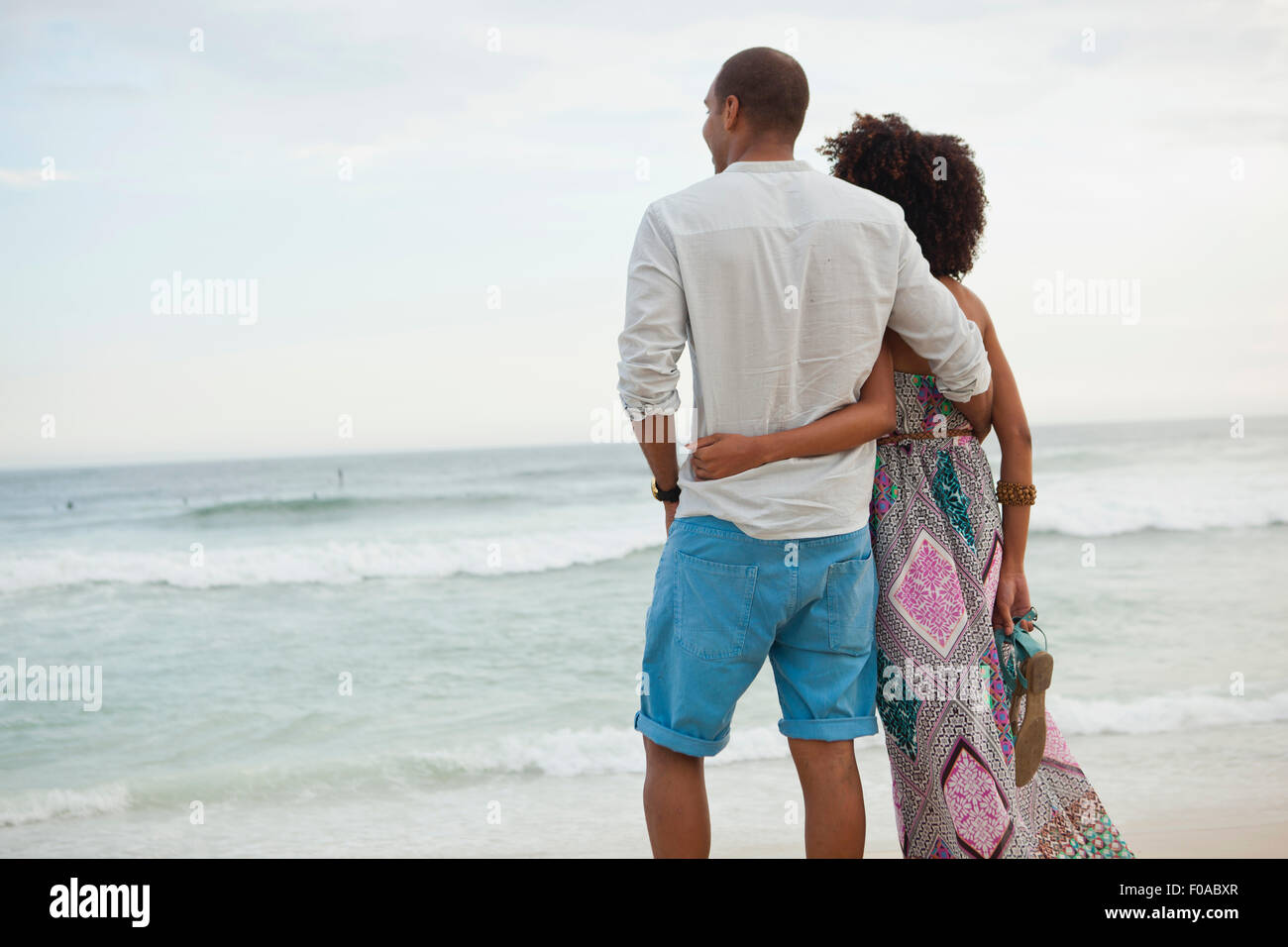 Couple looking out to sea from beach, Rio De Janeiro, Brazil Stock Photo