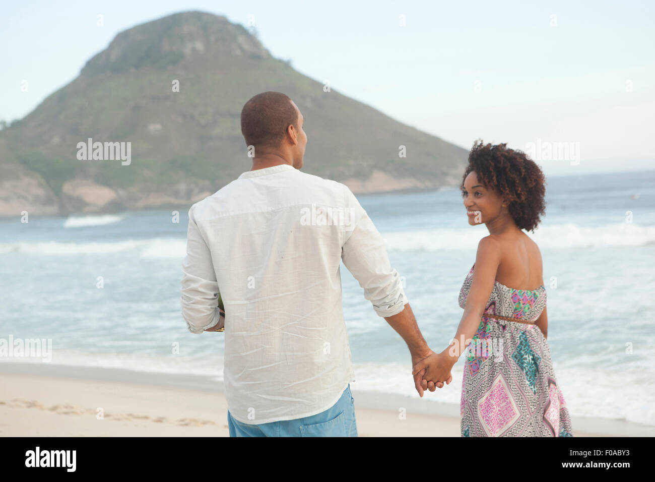 Couple strolling hand in hand on beach, Rio De Janeiro, Brazil Stock Photo