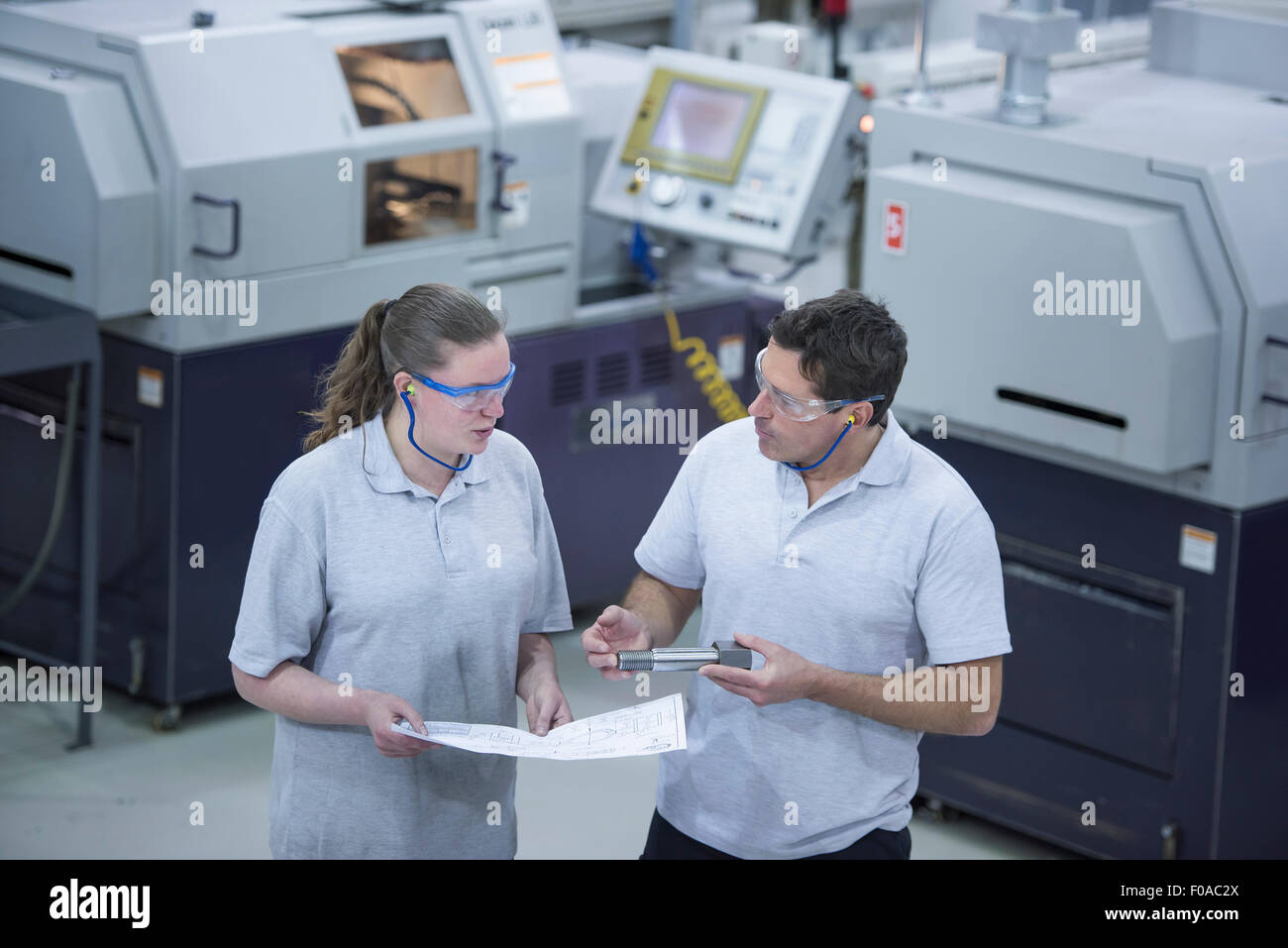 Male and female engineers discussing manufactured parts Stock Photo
