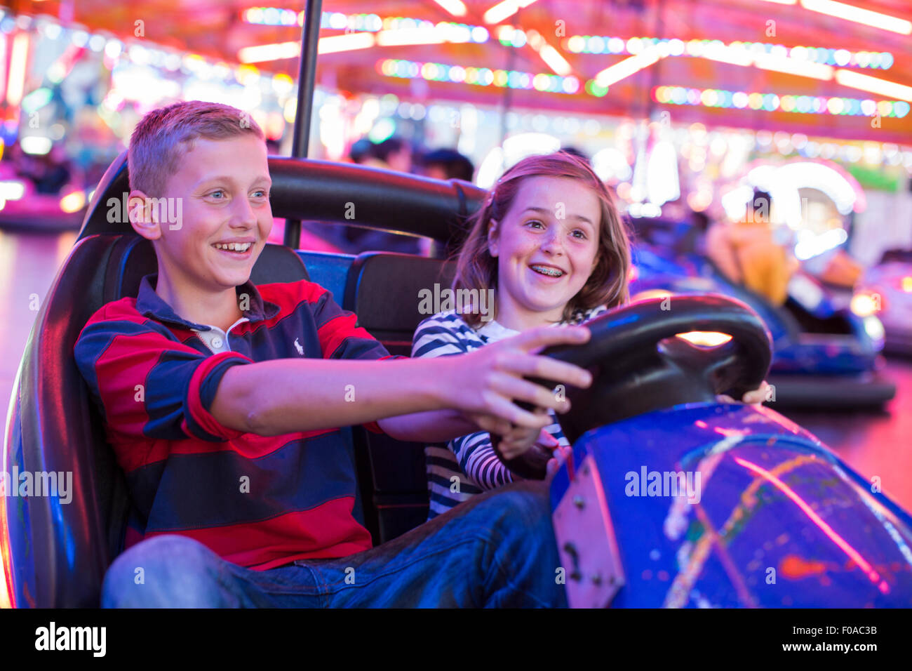Brother and sister on fairground bumper cars Stock Photo