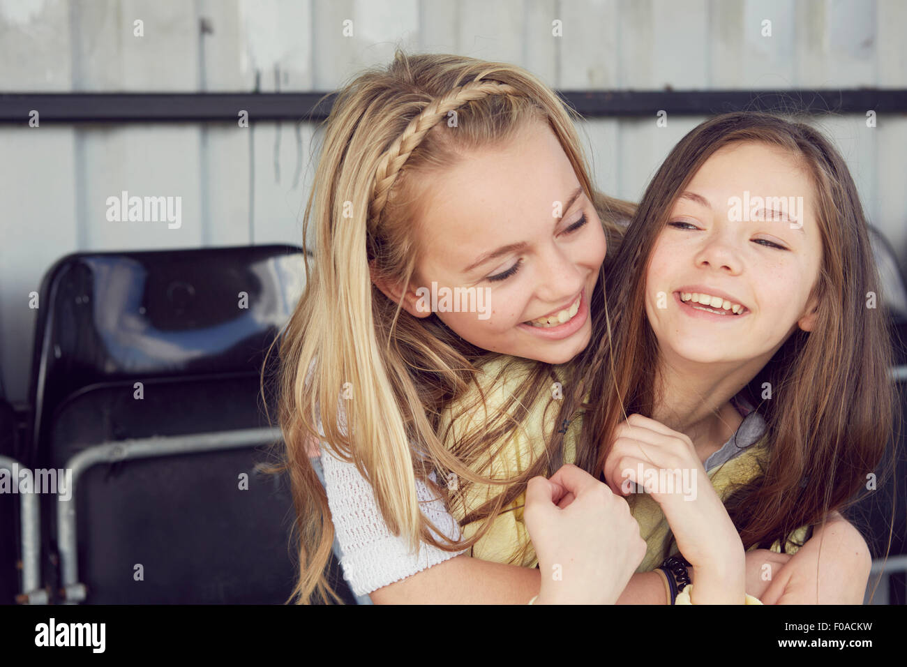 Portrait of two smiling girls hugging in stadium stand Stock Photo