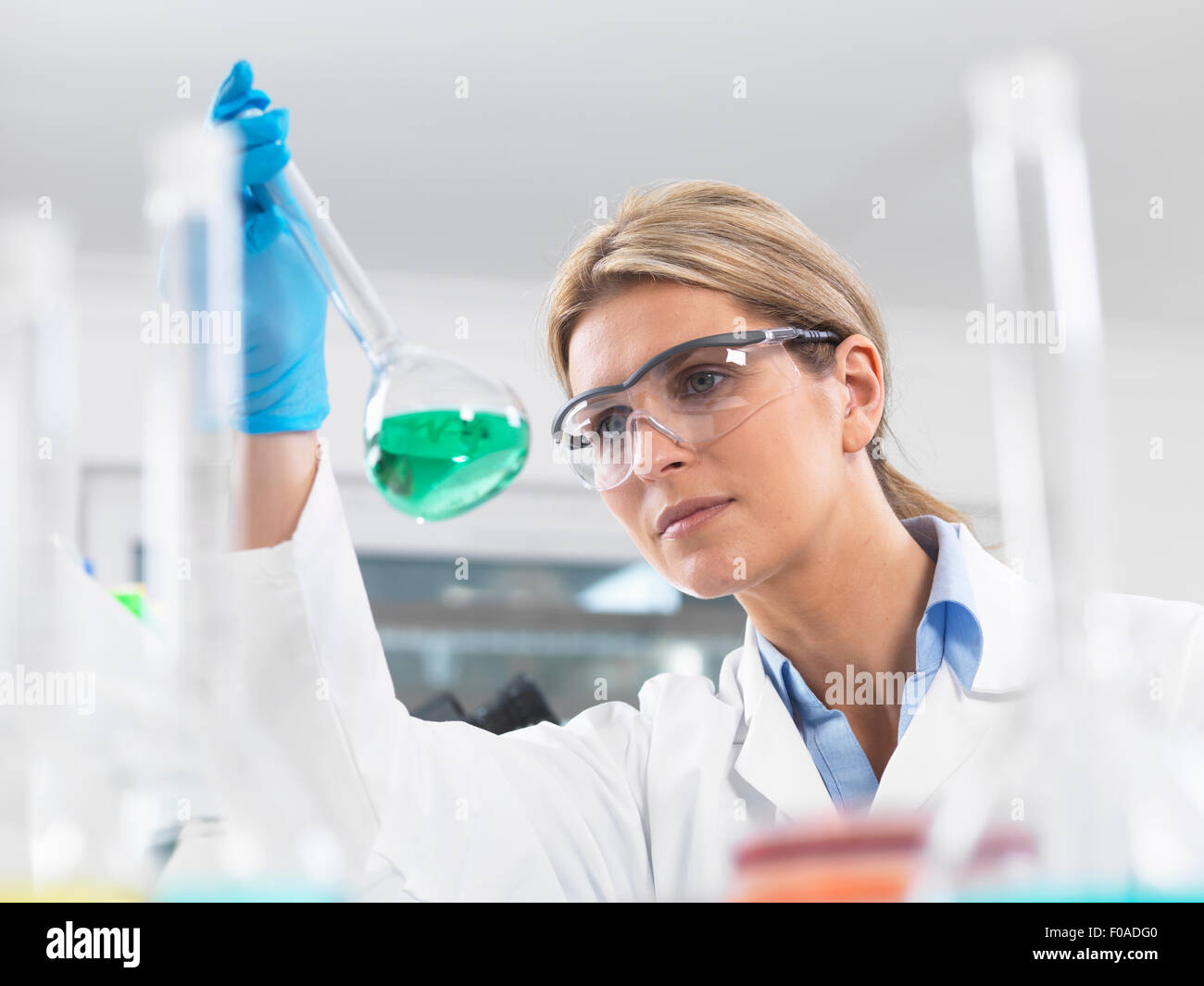 Scientist viewing chemical experiment in a laboratory Stock Photo
