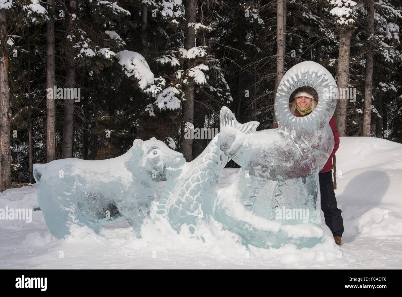 Young woman looking through ice sculpture Stock Photo