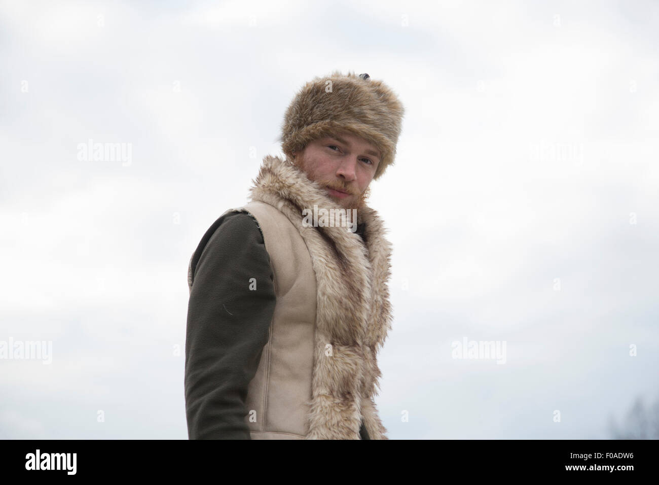 Mid adult man wearing furry waistcoat and trapper hat Stock Photo