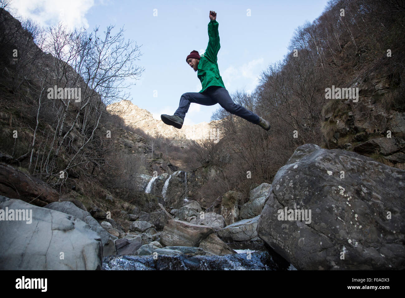 Man jumping over Toce River, Premosello, Verbania, Piedmonte, Italy Stock Photo