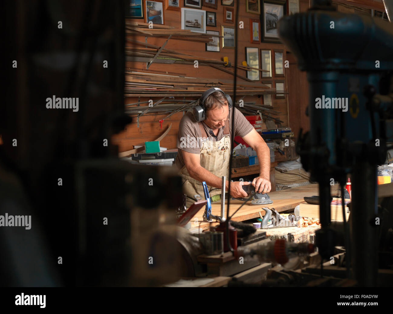 Boat builder sanding wood in workshop Stock Photo