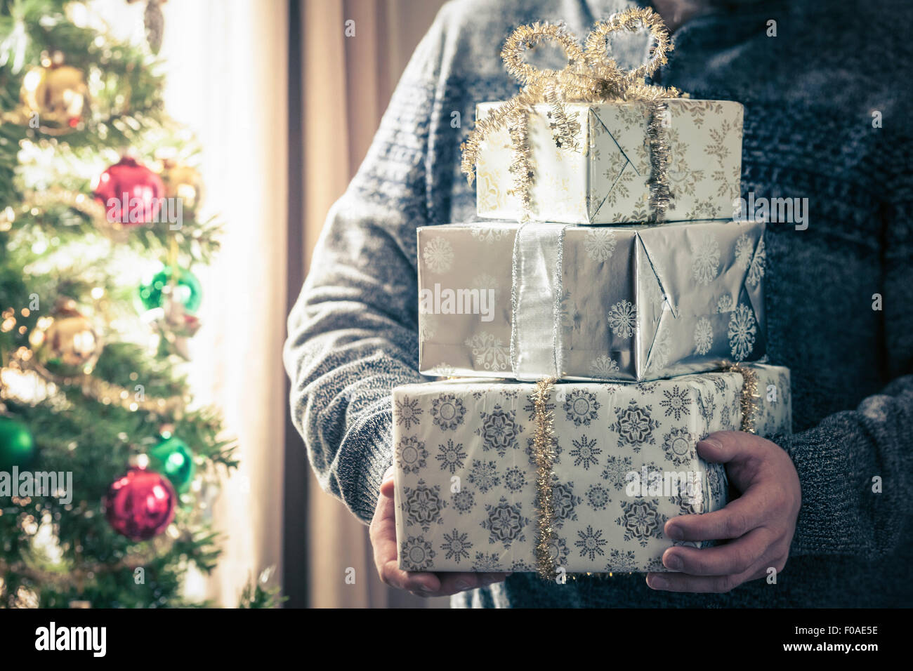 Person holding stack of christmas gifts Stock Photo
