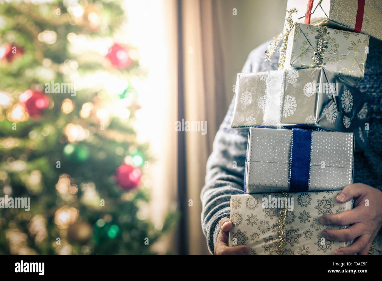 Person holding stack of christmas gifts Stock Photo