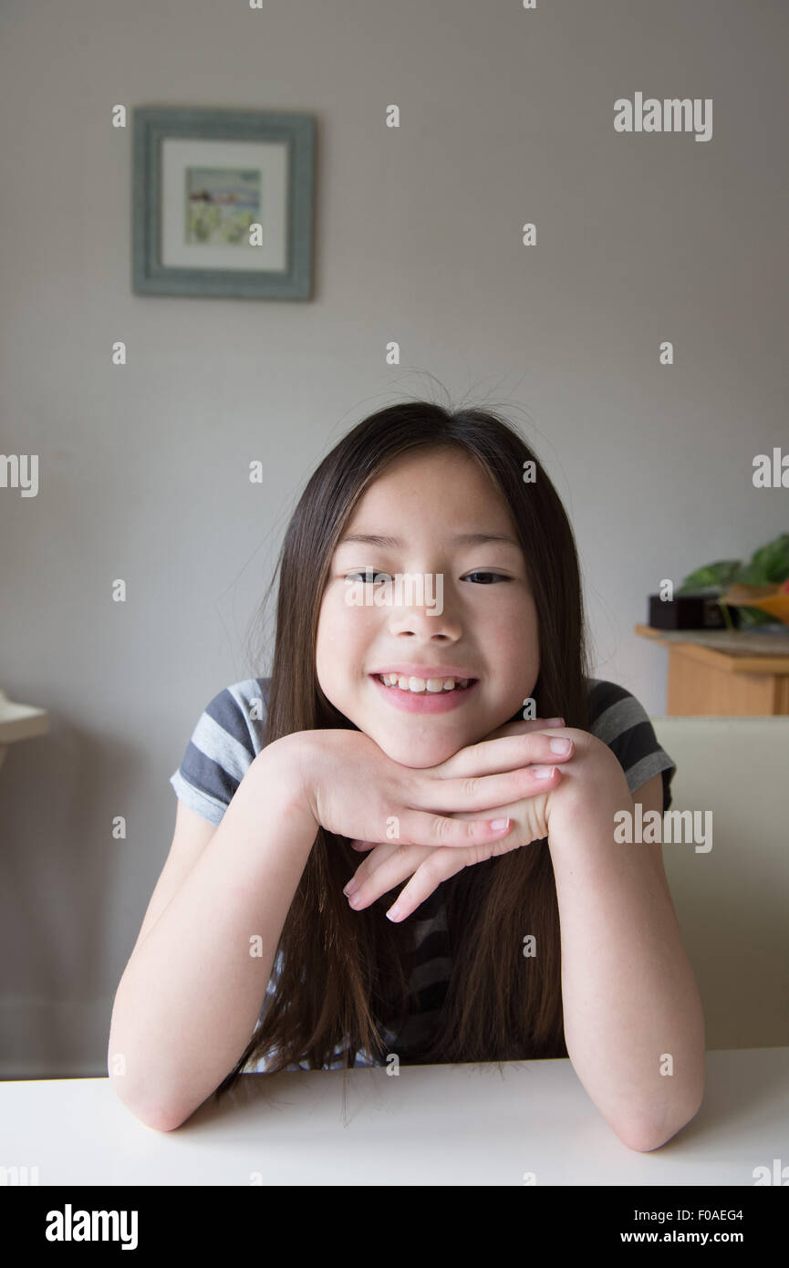 Portrait of cute smiling girl with chin on hands Stock Photo