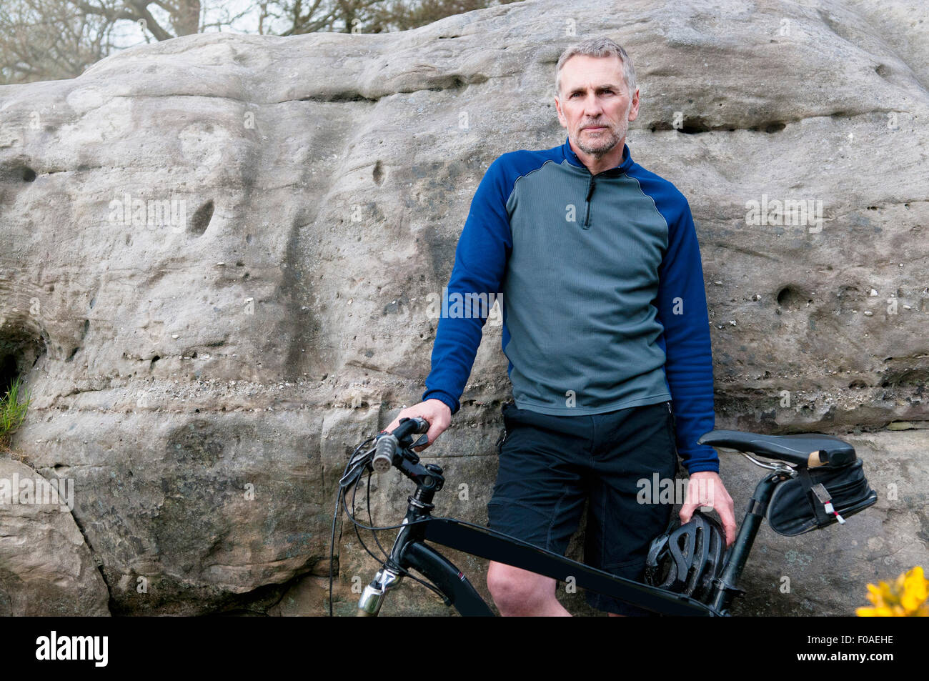 Portrait of male mountain biker on rock formation Stock Photo
