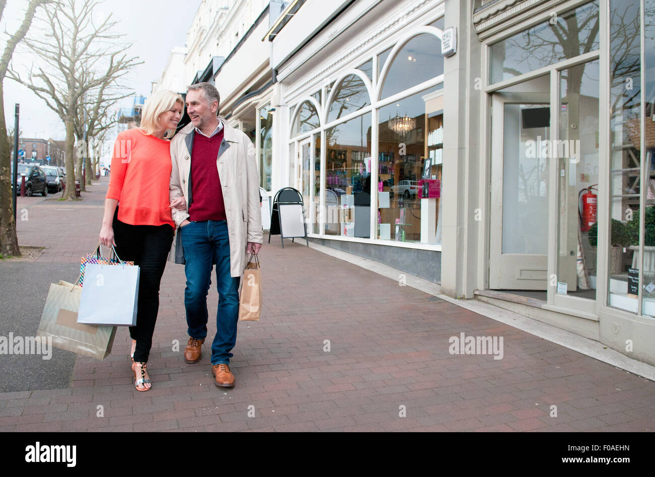 Couple carrying shopping  on village street Stock Photo