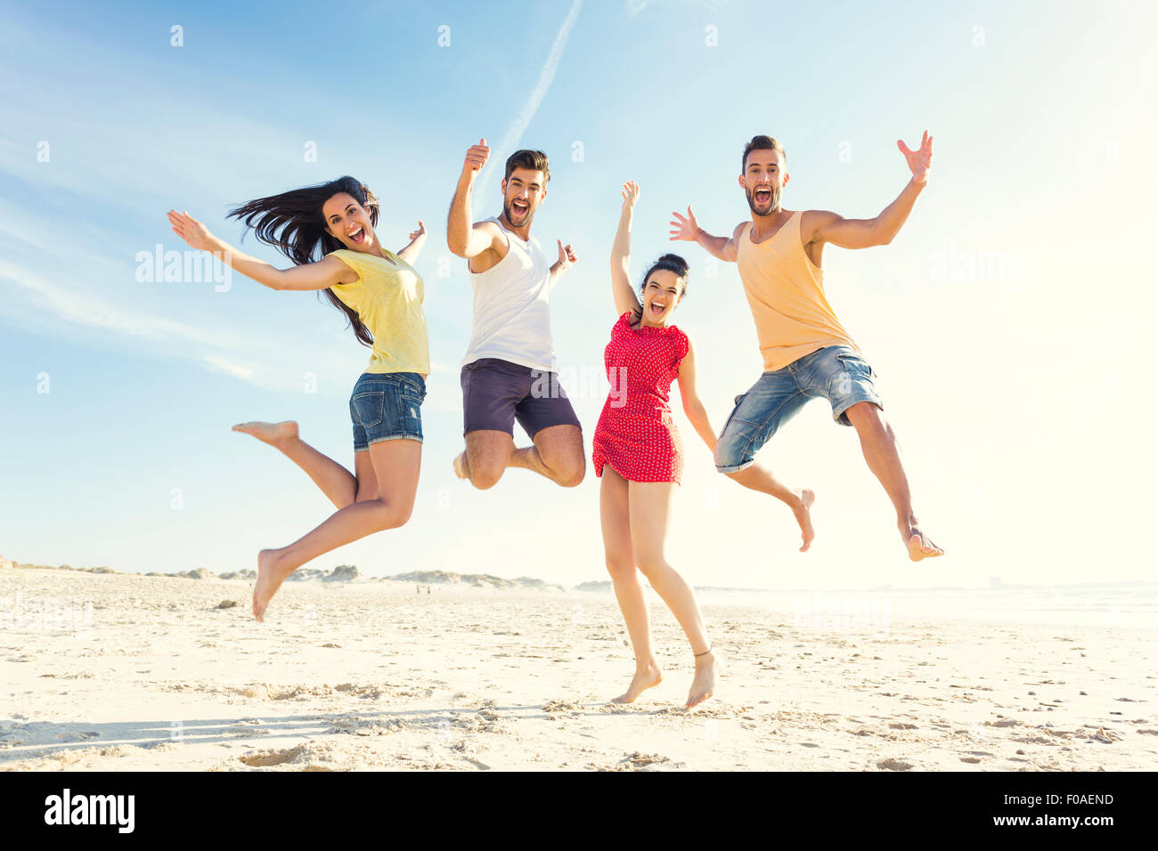 Group of friends making a jump together at the beach Stock Photo - Alamy