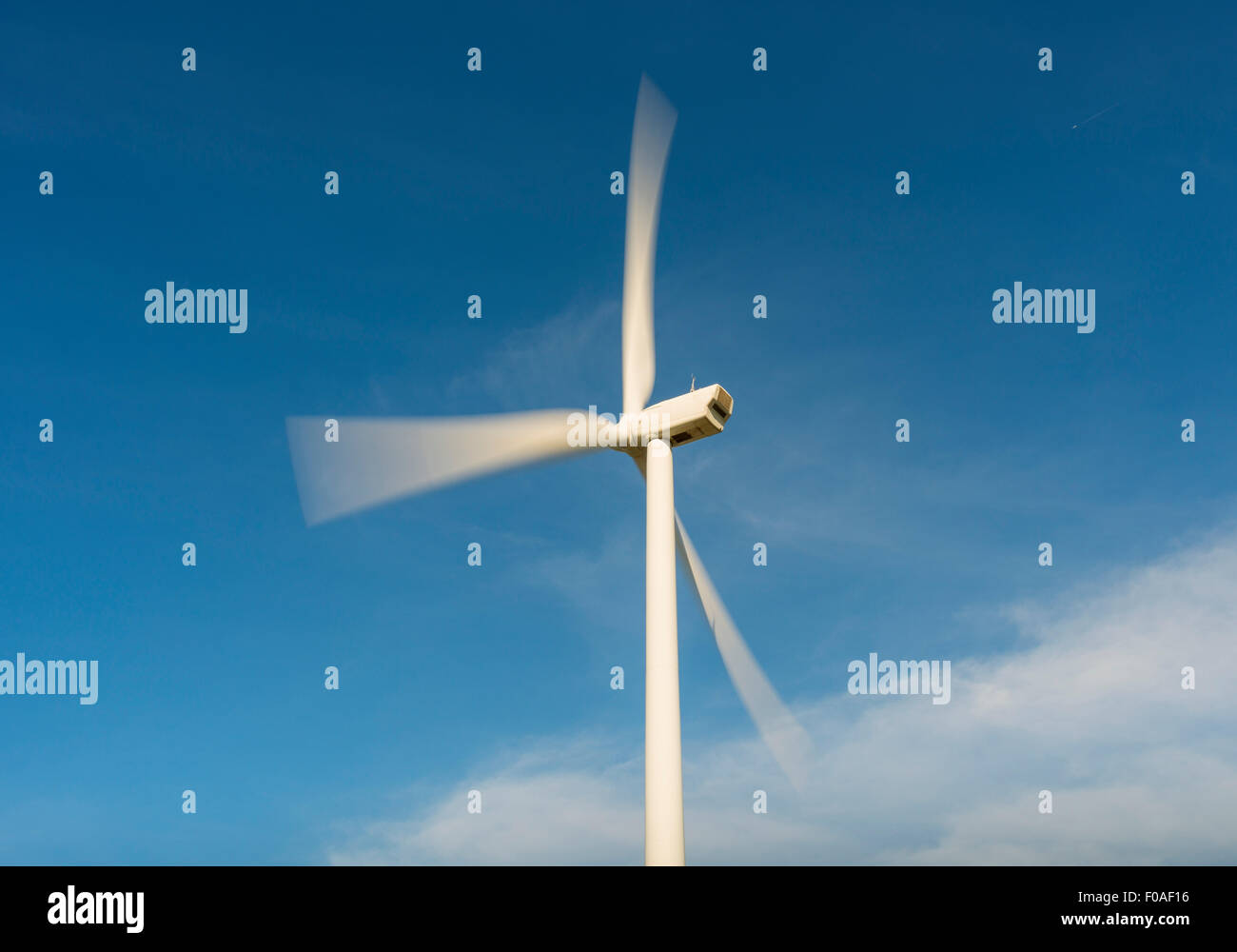 Wind turbine in motion against blue sky,  Netherlands Stock Photo