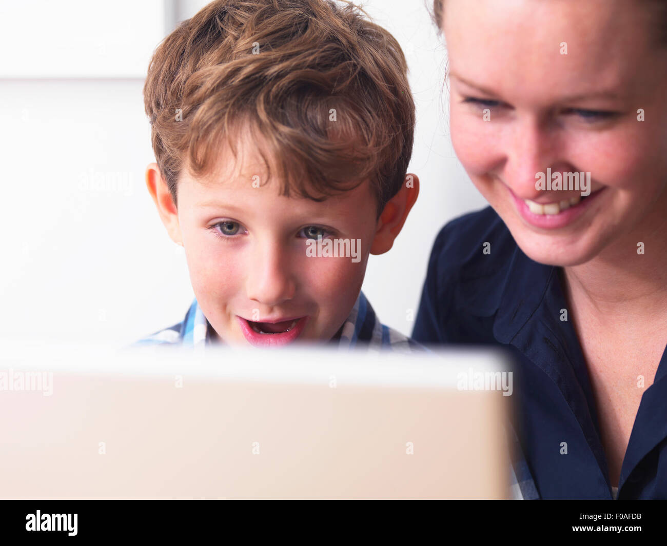 Close up of young woman and son using laptop Stock Photo
