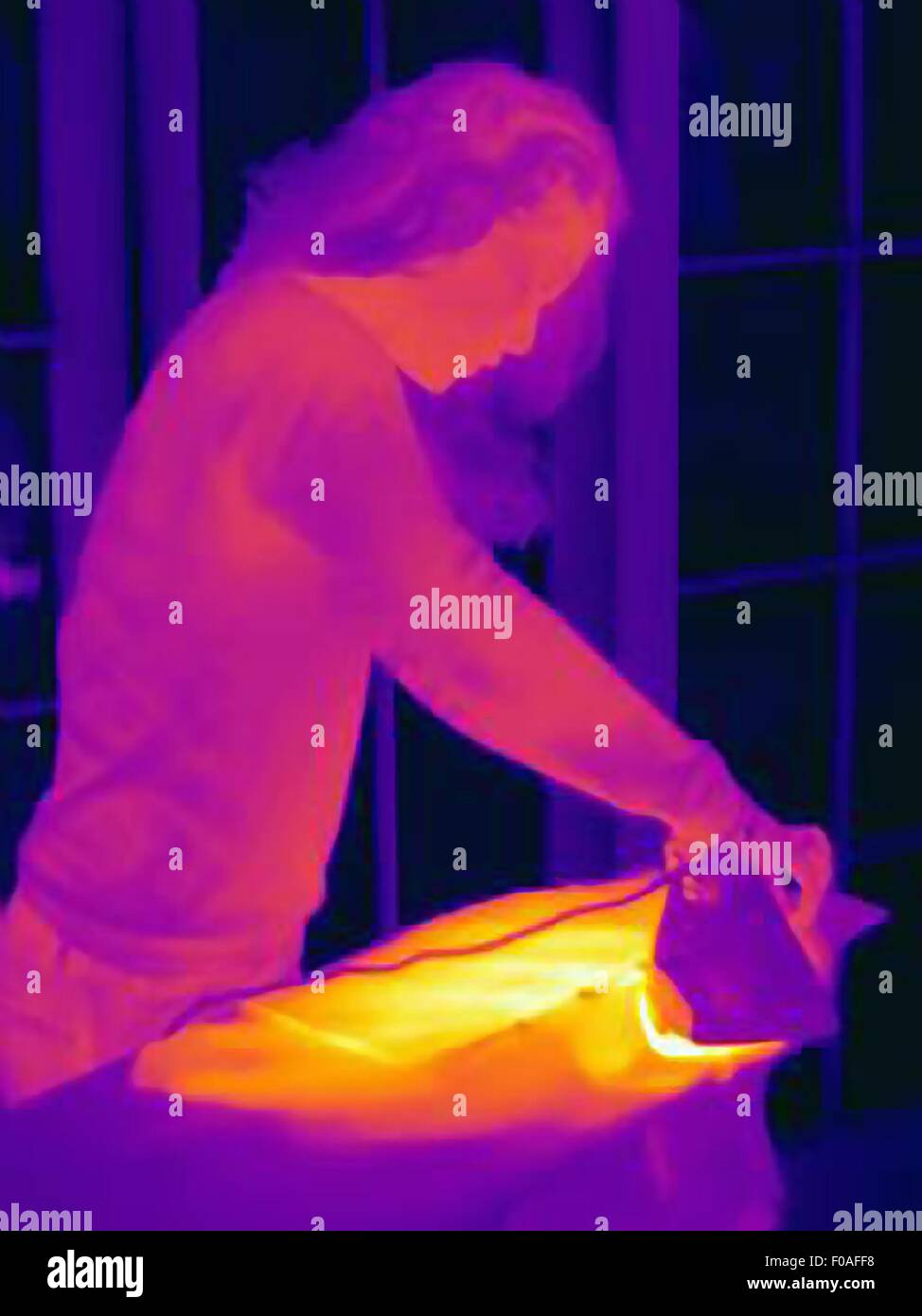 Thermal image of mature woman ironing at home Stock Photo