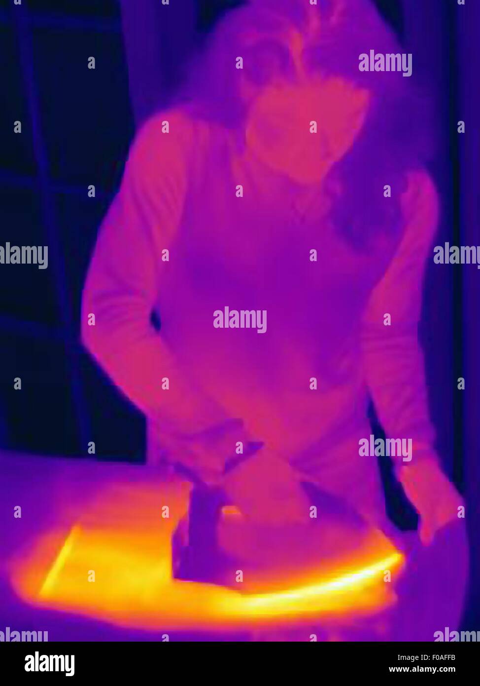 Thermal image of woman ironing at home Stock Photo