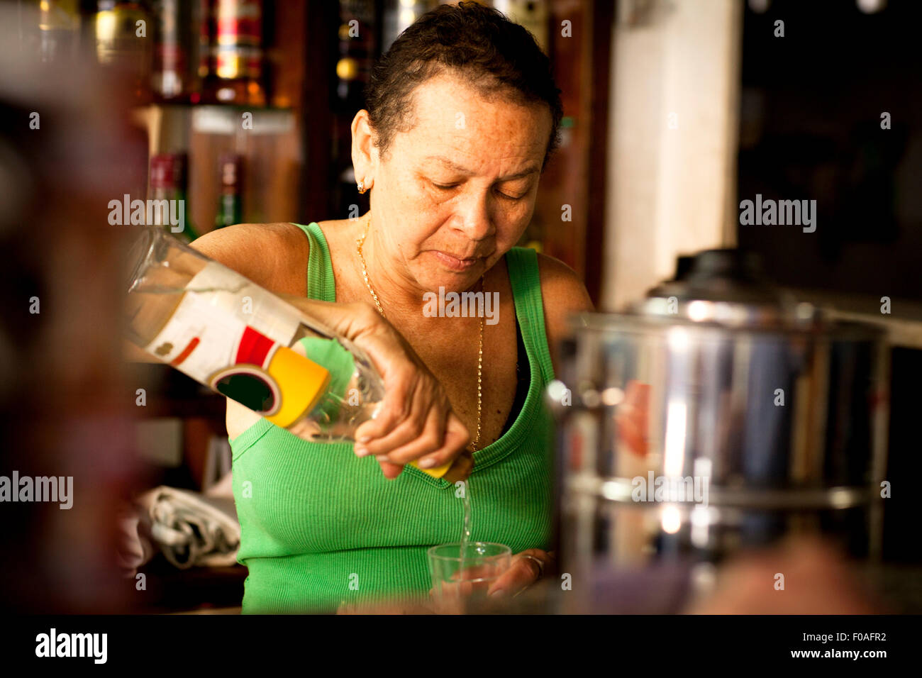 Woman serving liquor in bar Stock Photo